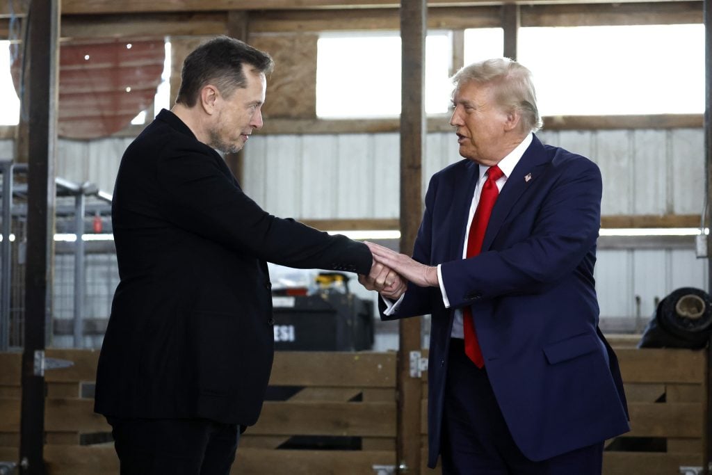 Elon Musk shakes hands with Republican presidential nominee, former President Donald Trump back stage during a campaign rally at the Butler Farm Show grounds on October 05, 2024 in Butler, Pennsylvania.