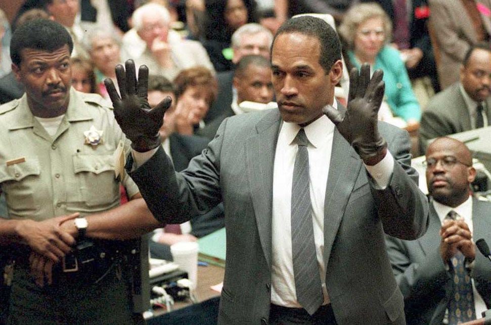 O.J. Simpson shows the jury a new pair of Aris extra-large gloves, similar to the gloves found at the Bundy and Rockingham crime scene 21 June 1995, during his double murder trial in Los Angeles, CA.