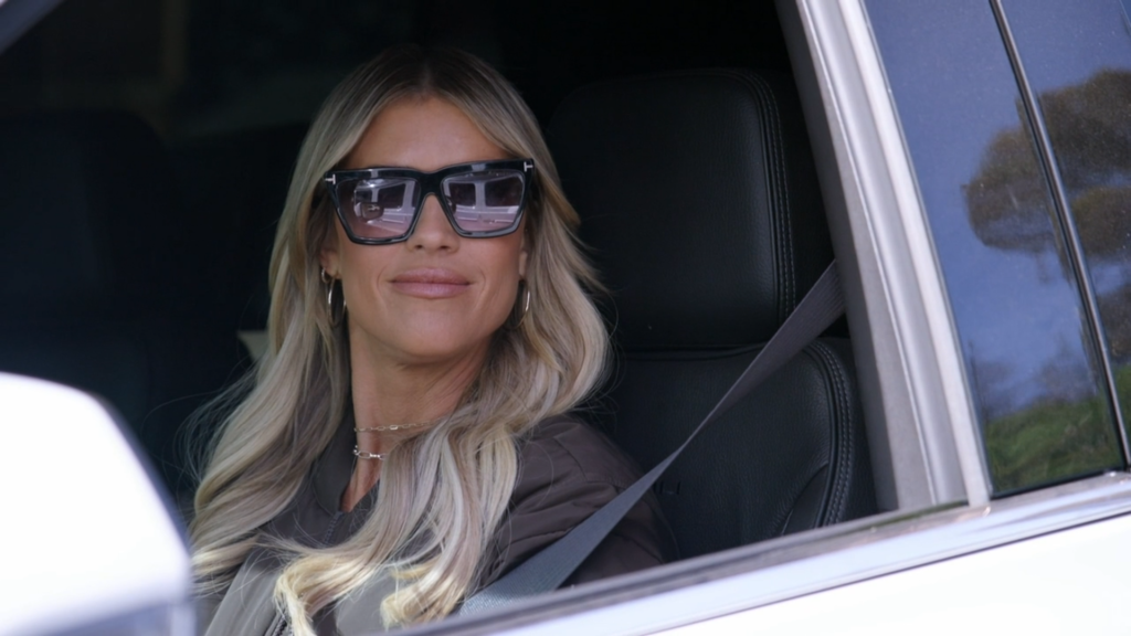 Christina Haack wears sunglasses in the car.