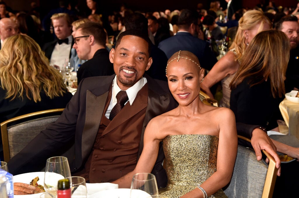 Jada Pinkett Smith and Will Smith seated at a table in March of 2022.