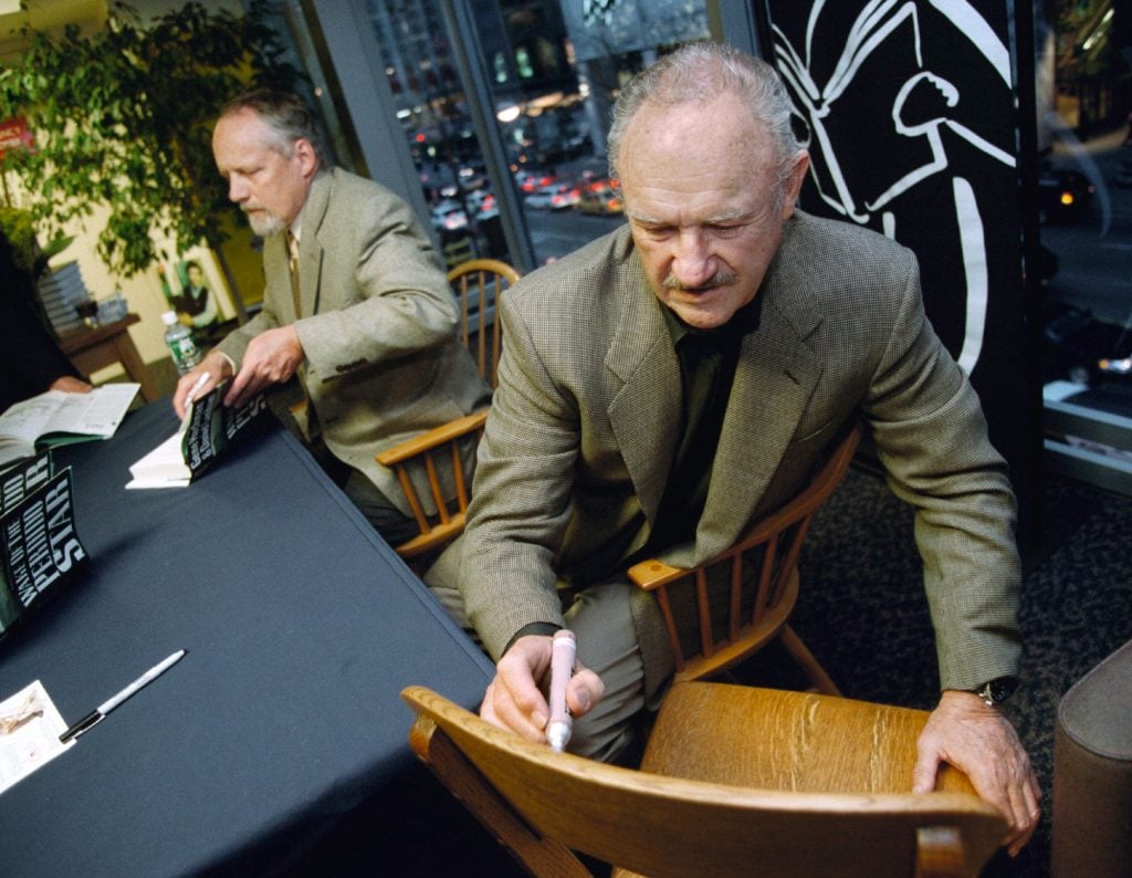 Gene Hackman signs a chair for a fan while also signing posters from his movie "The French Connection" at a Borders book store in Chicago April 28, 2000.