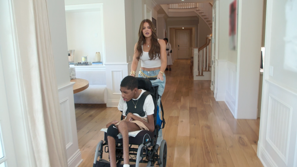 Khloe Kardashian helps Amari Thompson down the hall.