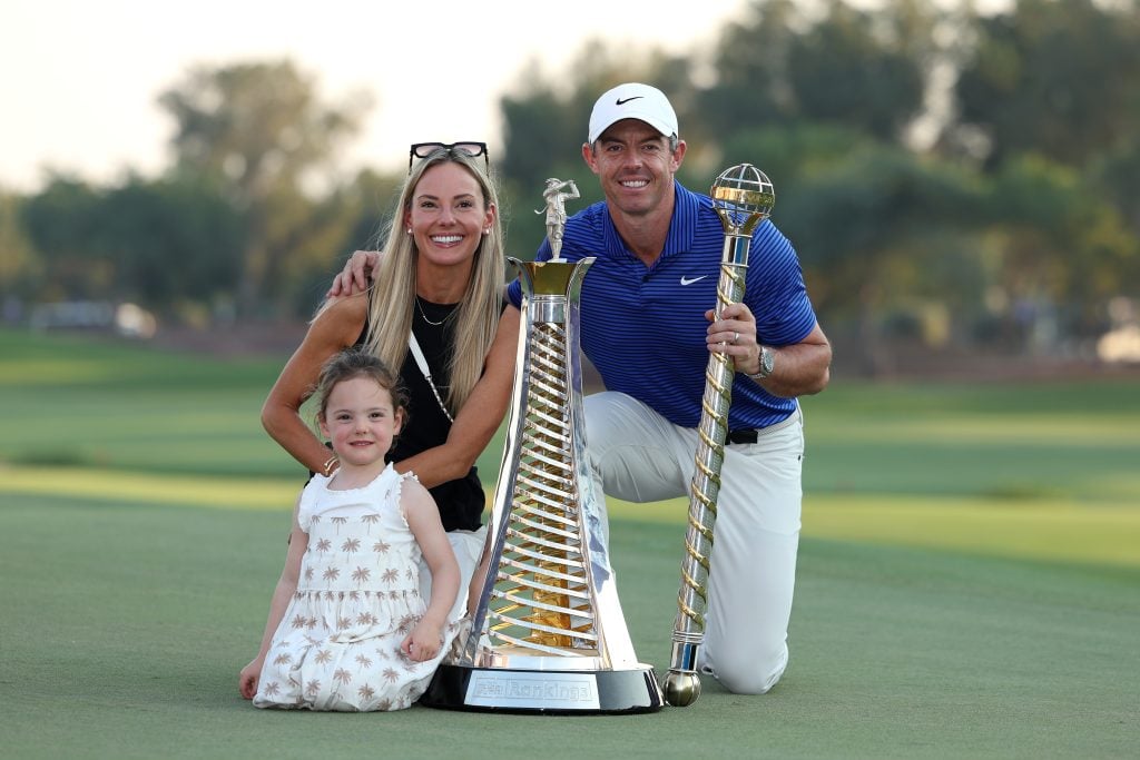 Rory McIlroy of Northern Ireland poses with his Wife, Erica Stoll and Daughter, Poppy McIlroy alongside the DP World Tour Championship trophy and the Race to Dubai trophy on the 18th green following victory on day four of the DP World Tour Championship 2024 at Jumeirah Golf Estates on November 17, 2024 in Dubai, United Arab Emirates.